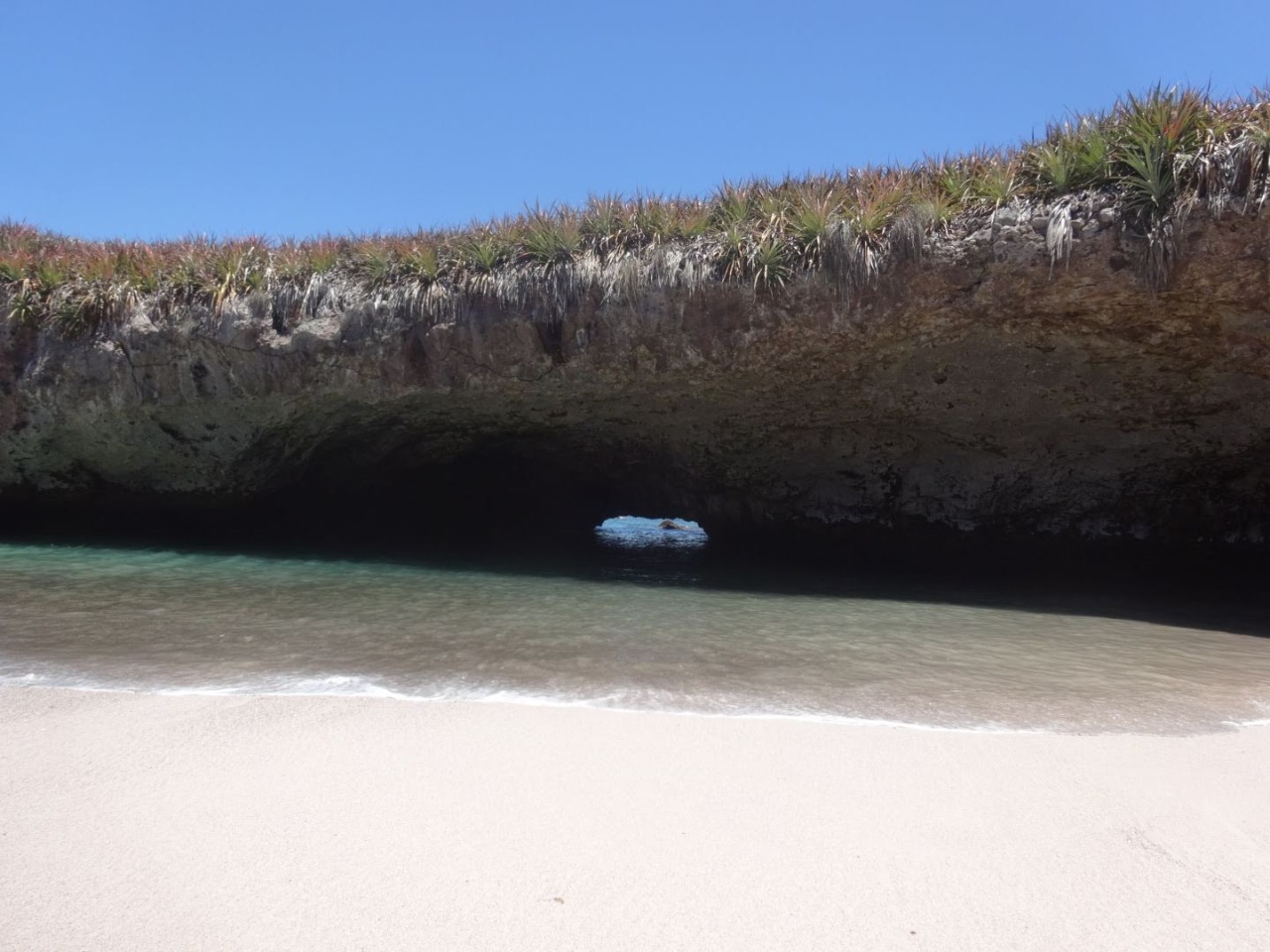 Túnel de roca por el que se entra nadando a la Playa Escondida, visto desde la arena